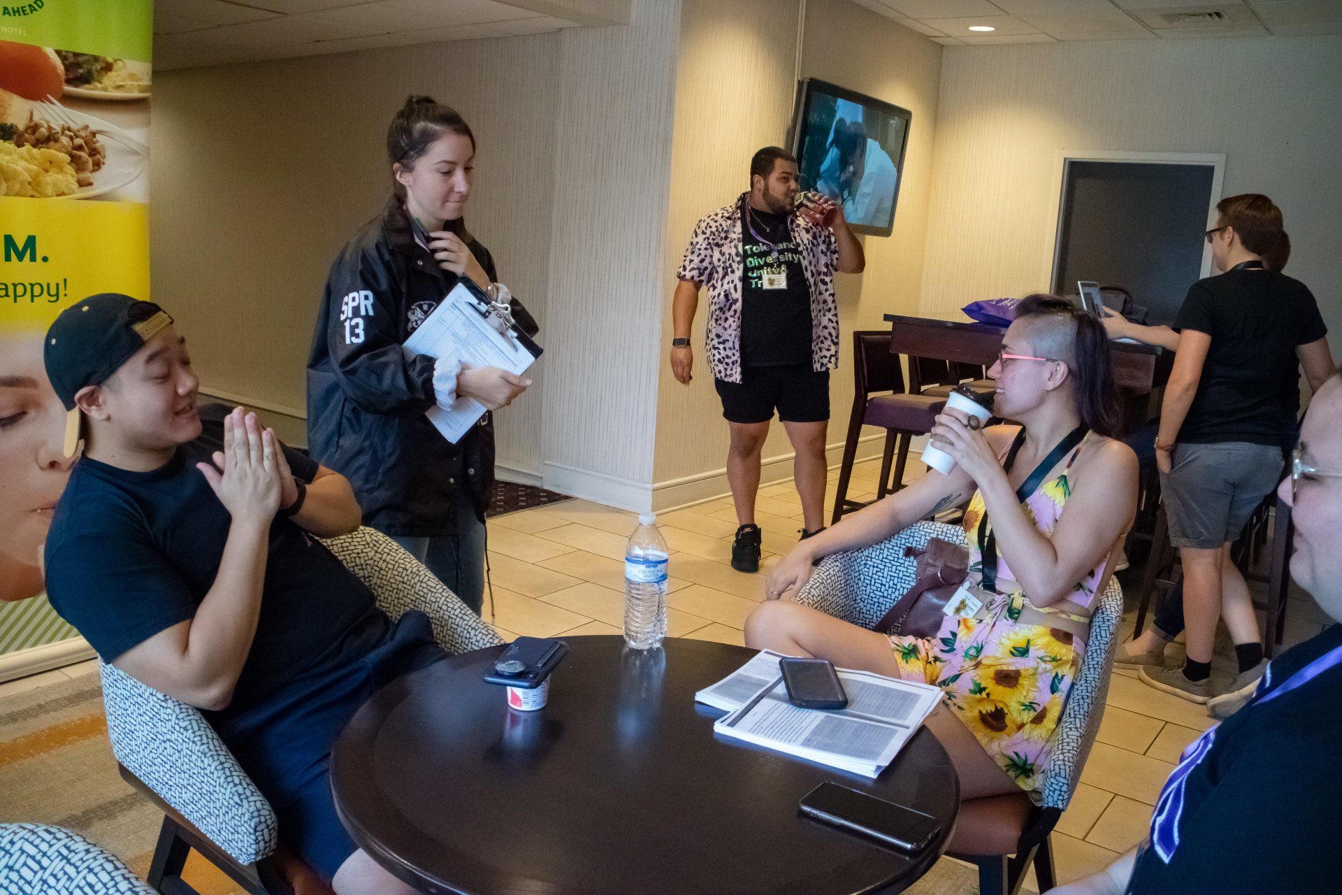 A group of people sit at the hotel restaurant, chatting.