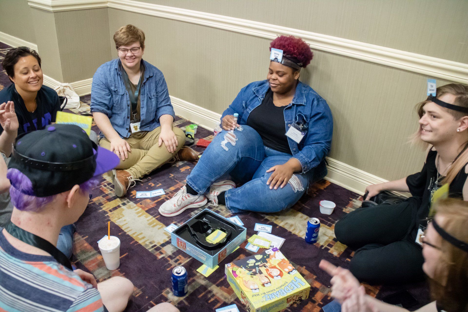 A large group of people siting on the floor, playing a game.