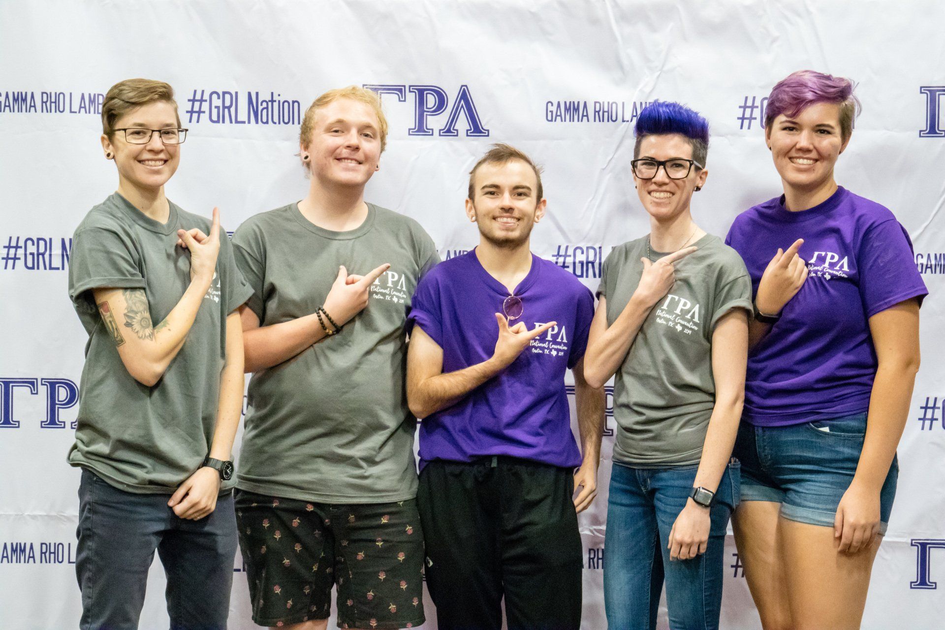 A group of people holding up a hand sign