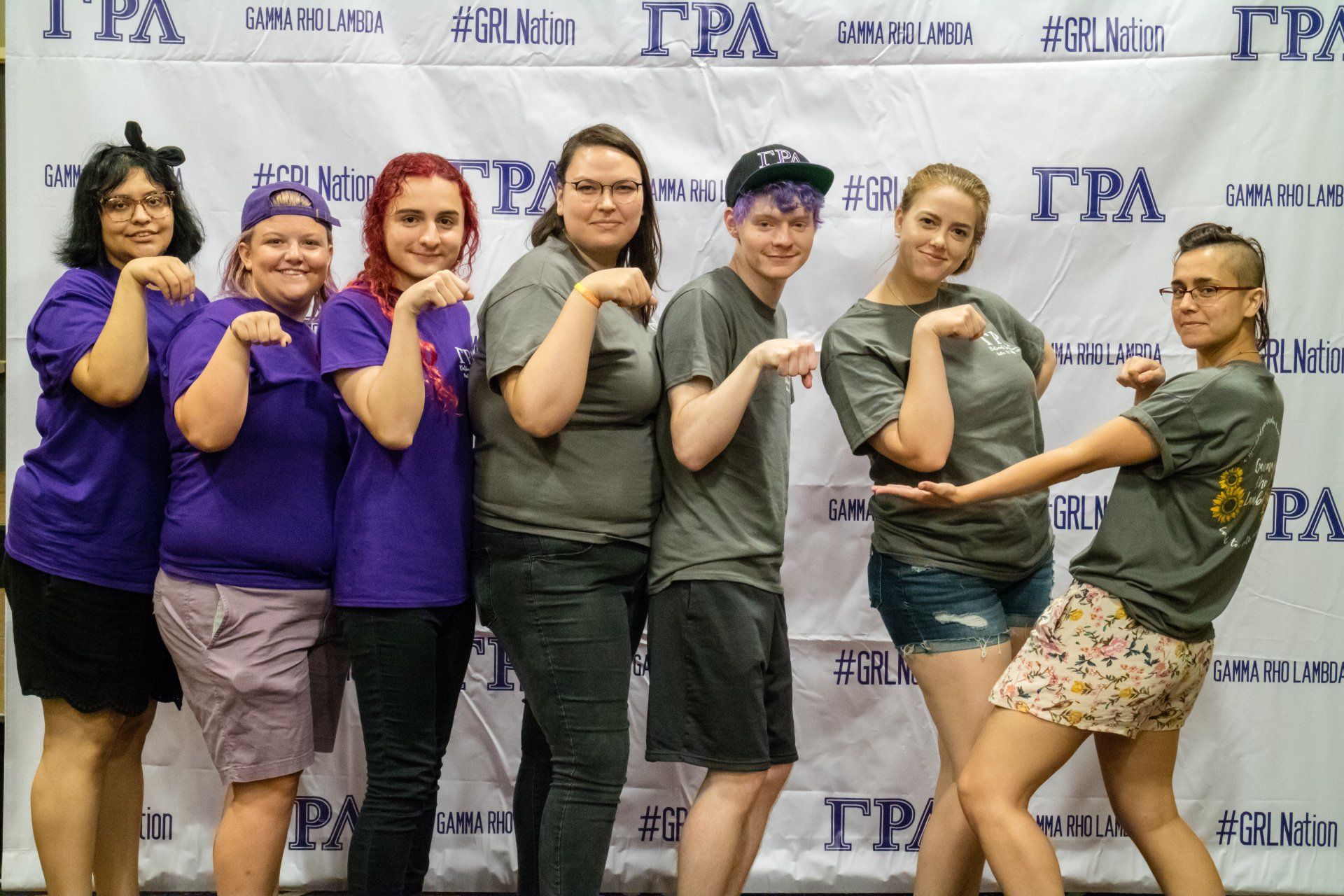 A group of people pose together with the arms up in a cat's paw shape.