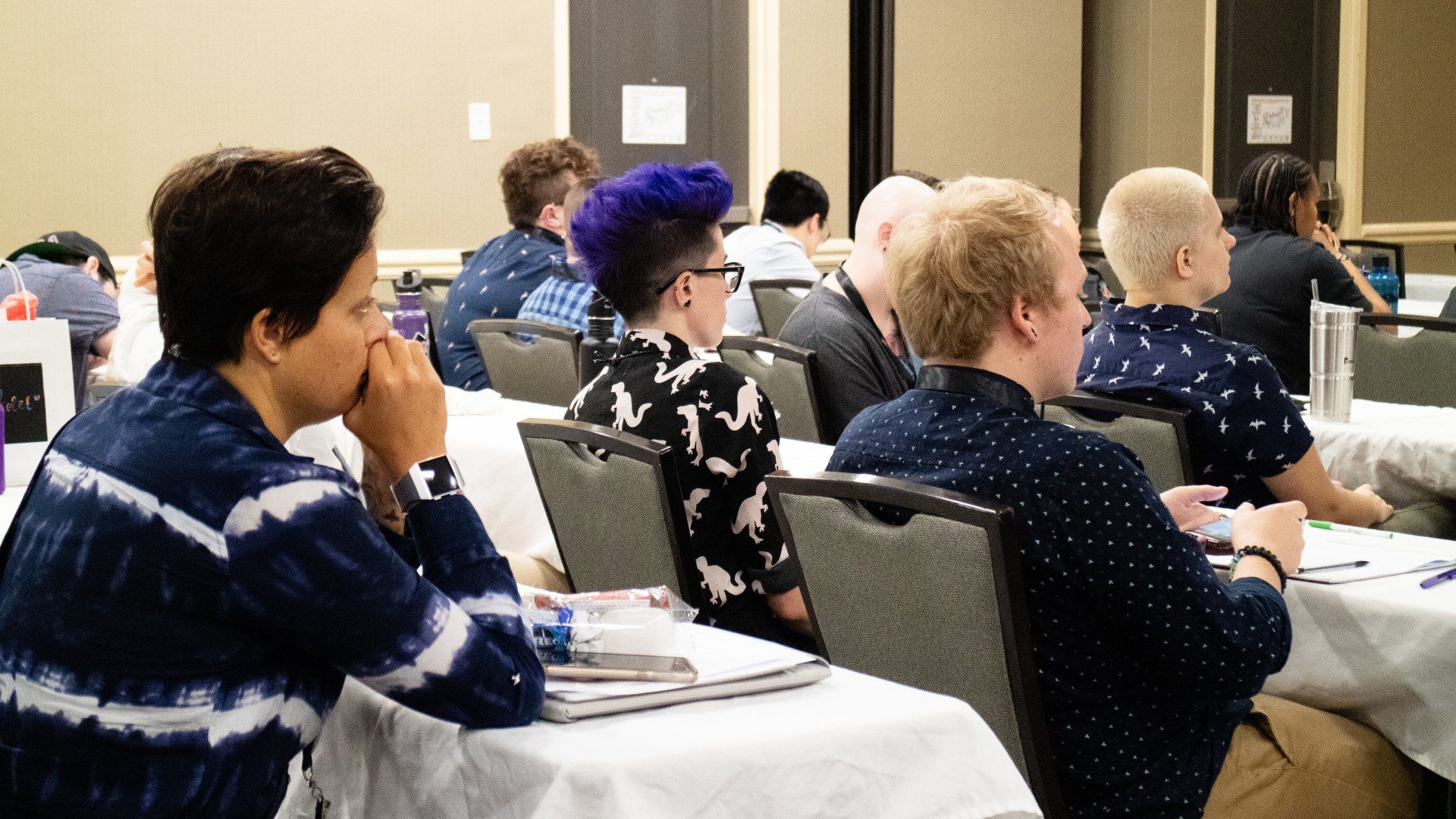 A group of people sit focused on a presentation