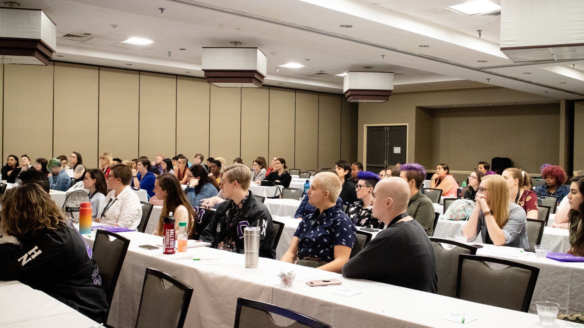 A group of people sit focused on a presentation