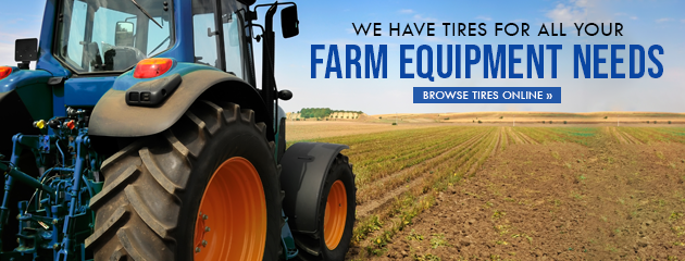 Blue tractor in a field advertises farm equipment tires.