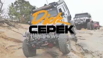 Off-road Jeep climbing a sandy hill with Dick Cepek logo, other Jeeps in background.