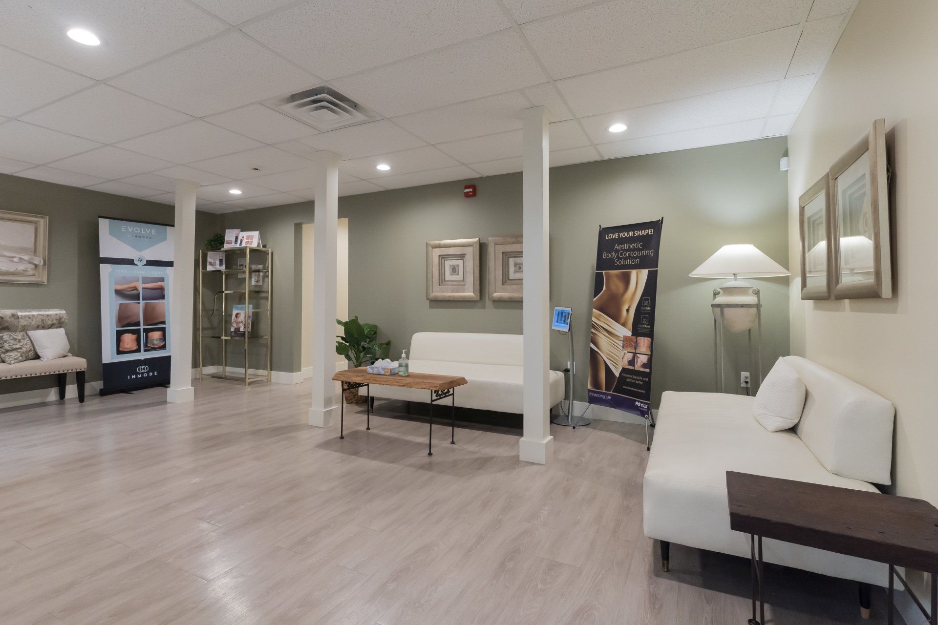 A waiting room with a couch , table , and chairs.