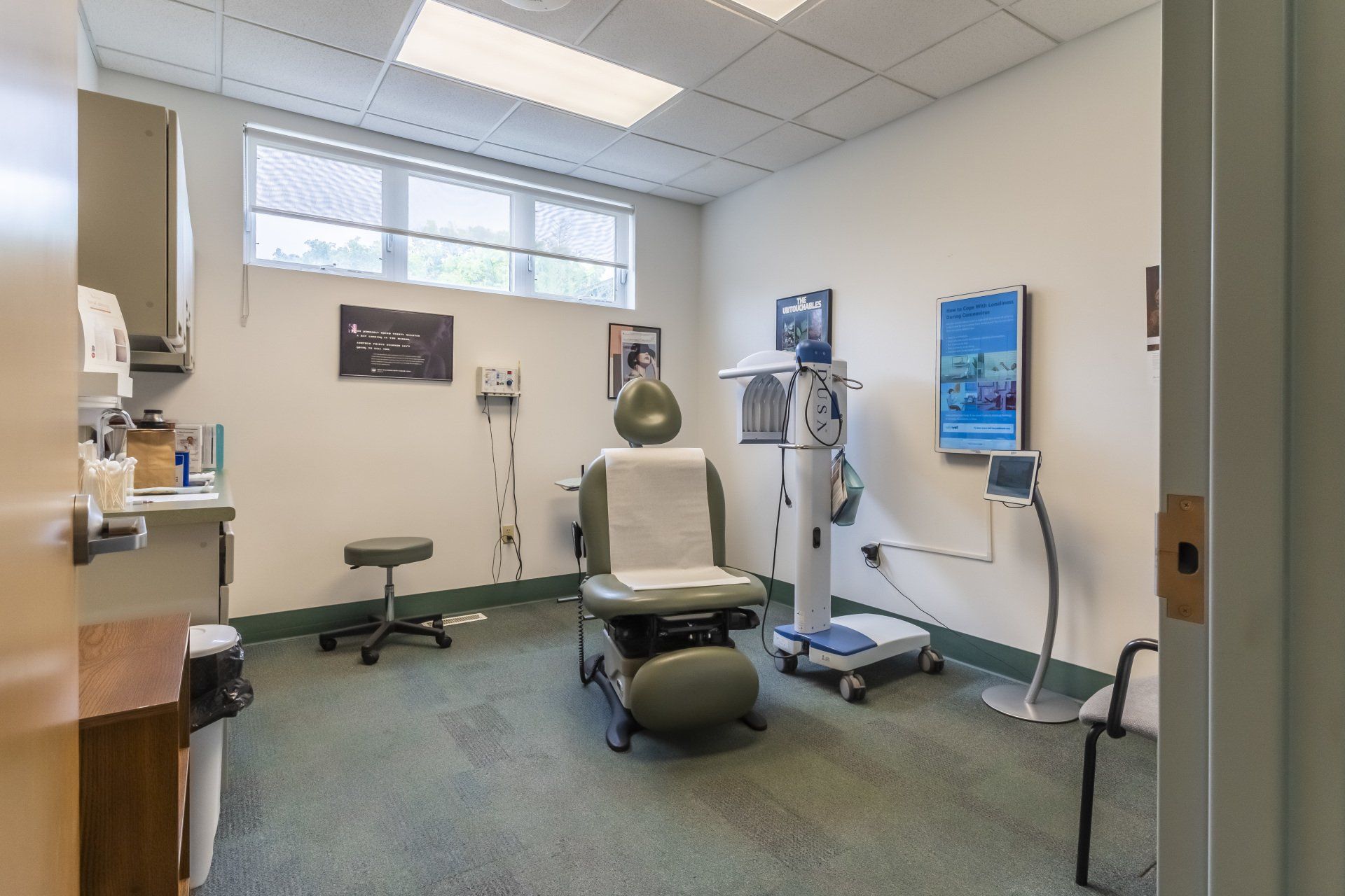 A dermatologist's office with a chair and a monitor
