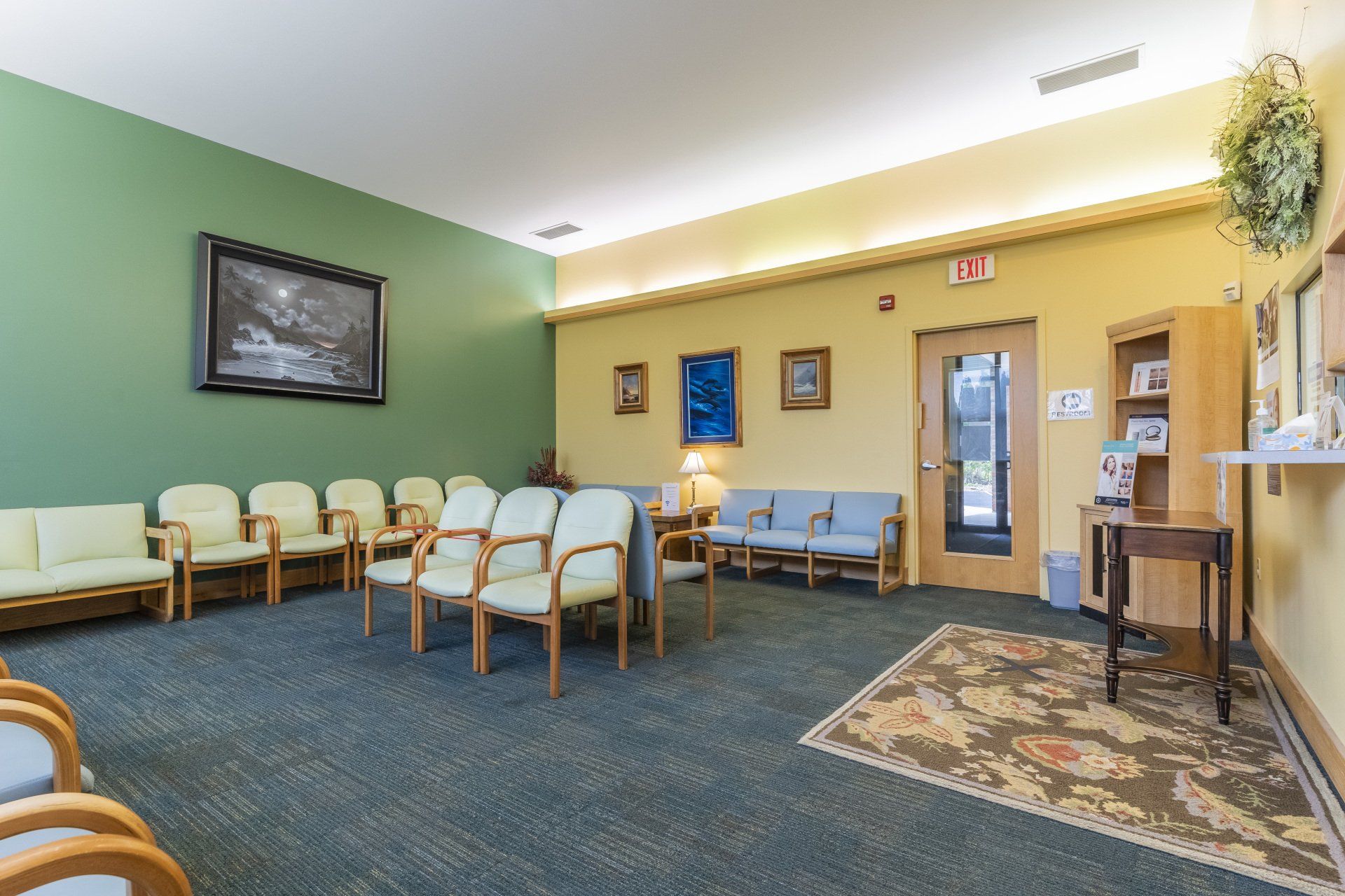 A waiting room with a lot of chairs and a picture on the wall.