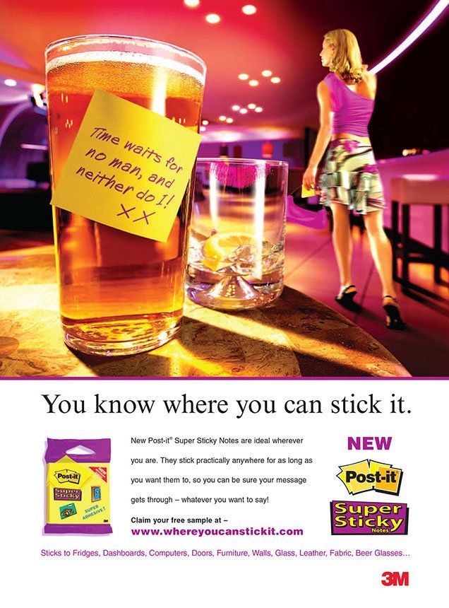A woman standing next to a glass of beer with a note on it that says