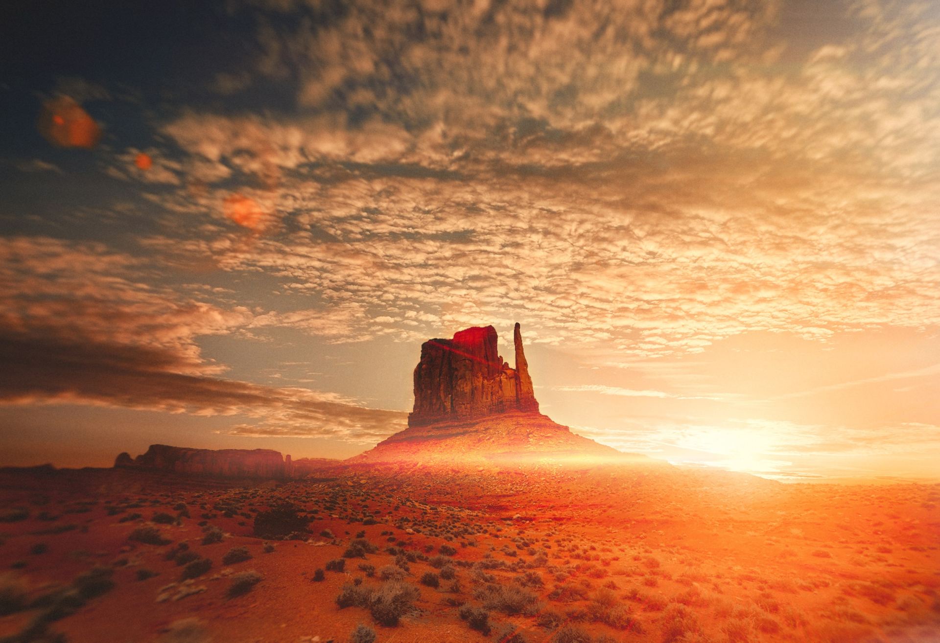 A desert landscape with a large rock formation in the foreground