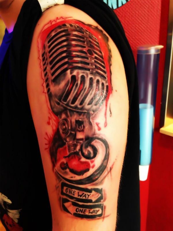 Ein Mann hat ein Mikrofon-Tattoo auf seinem Arm