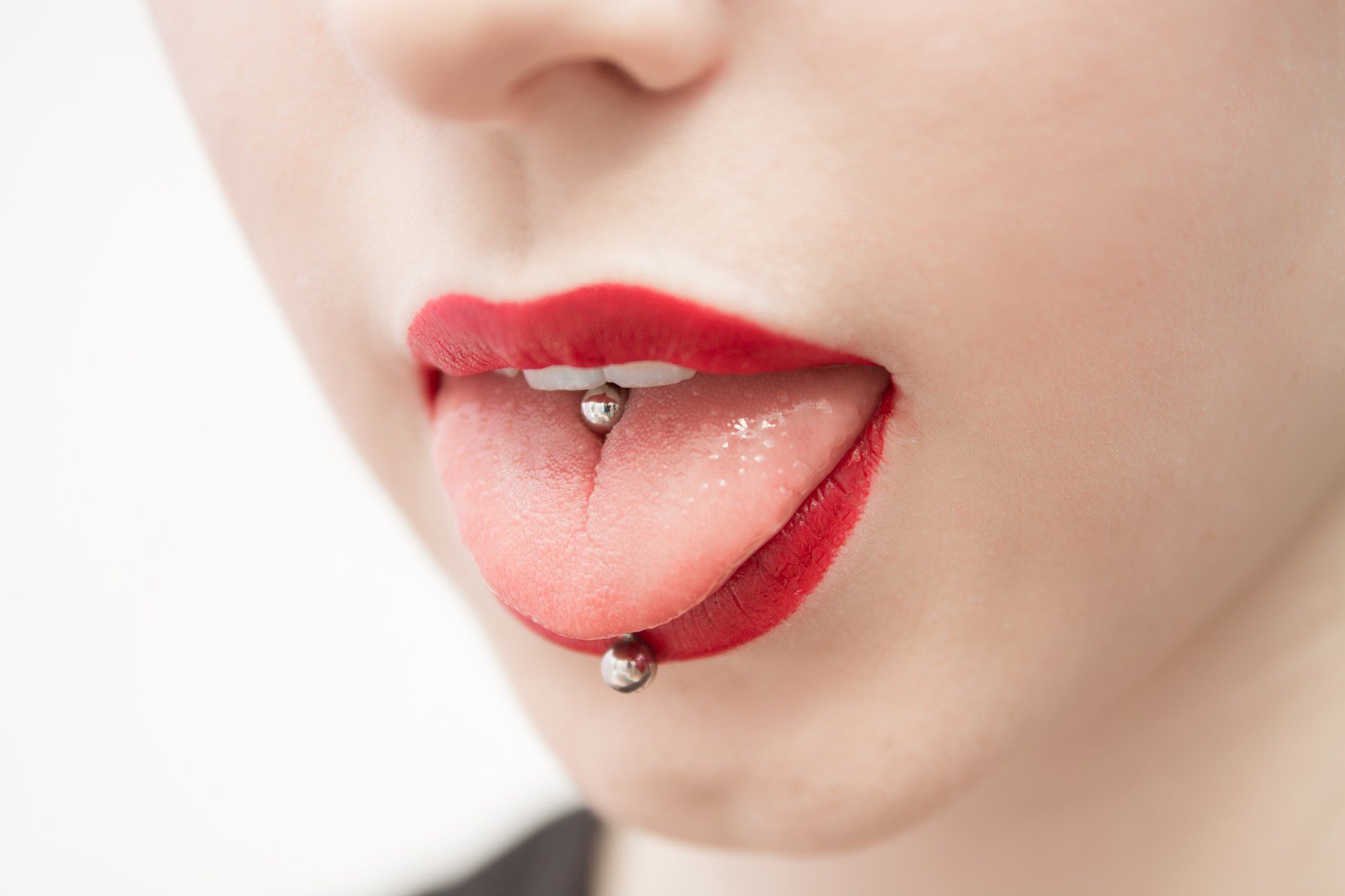 Eine Nahaufnahme der Zunge einer Frau mit einem Piercing.