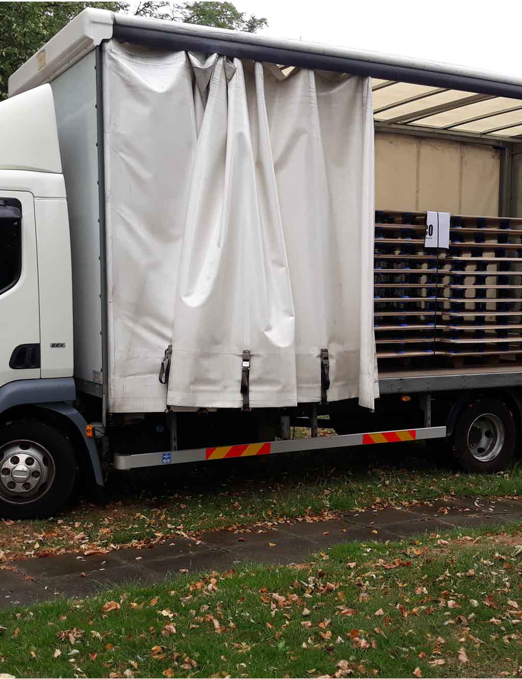 Truck with the curtain pulled back and pallets inside