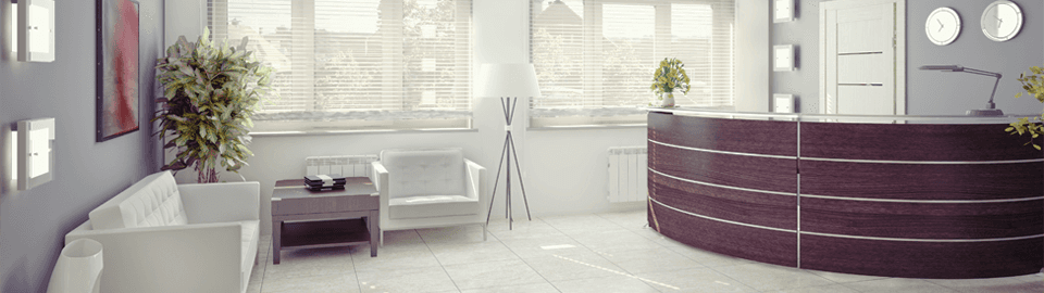 A white reception area with dark wood circular desk