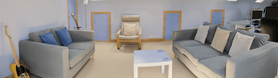 A white coffee table between two grey sofas