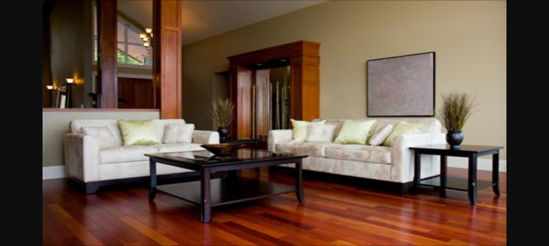 Two cream brocade sofas around a black square coffee table on a dark wood floor