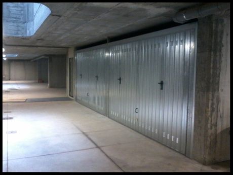 vista laterale di un auto da parcheggiare in un garage con la serranda a metà