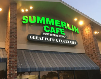 Summerlin Cafe sign in green, white, and black. Located in Fort Myers Beach, under a gray awning.