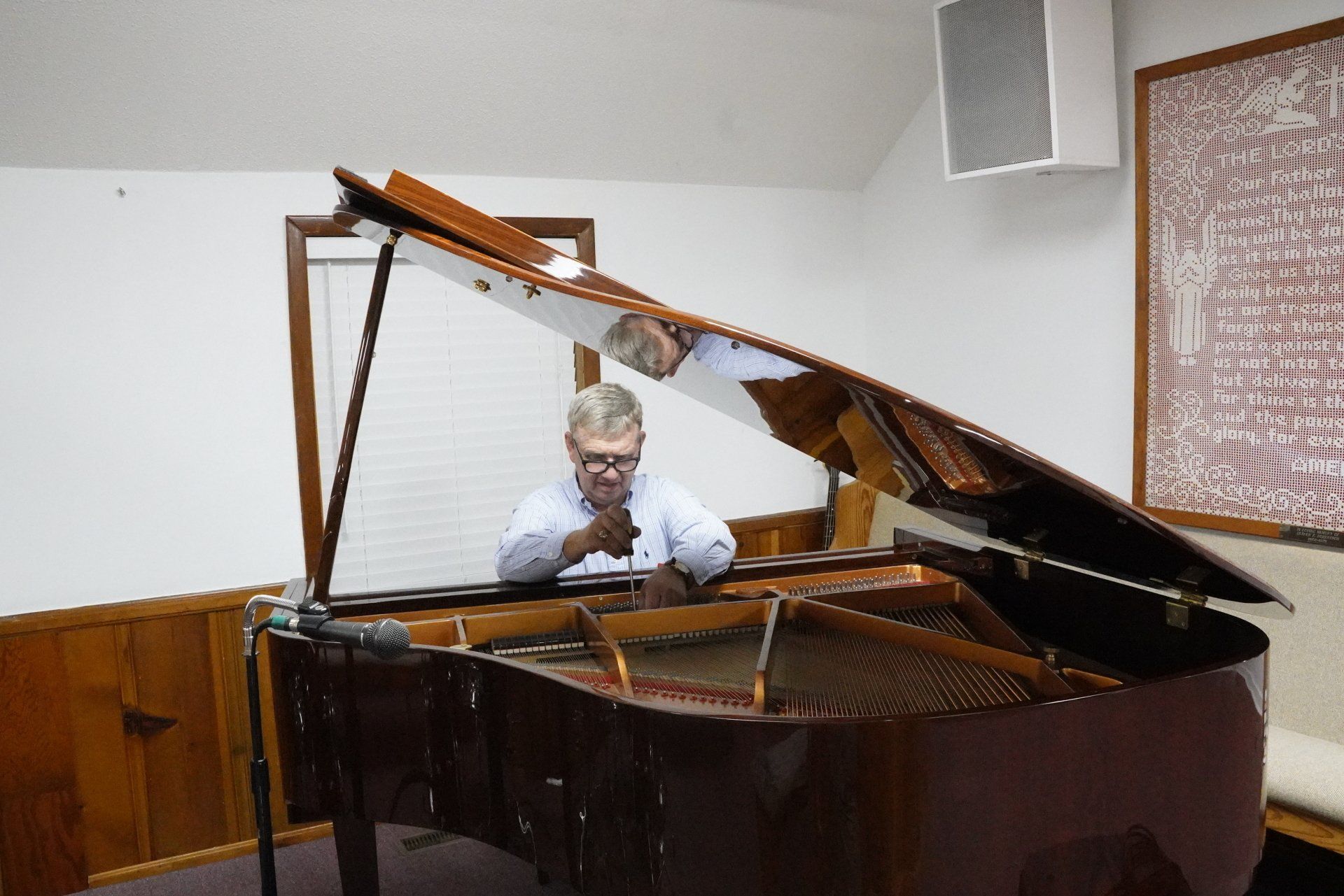 A man is sitting at a piano with the lid open