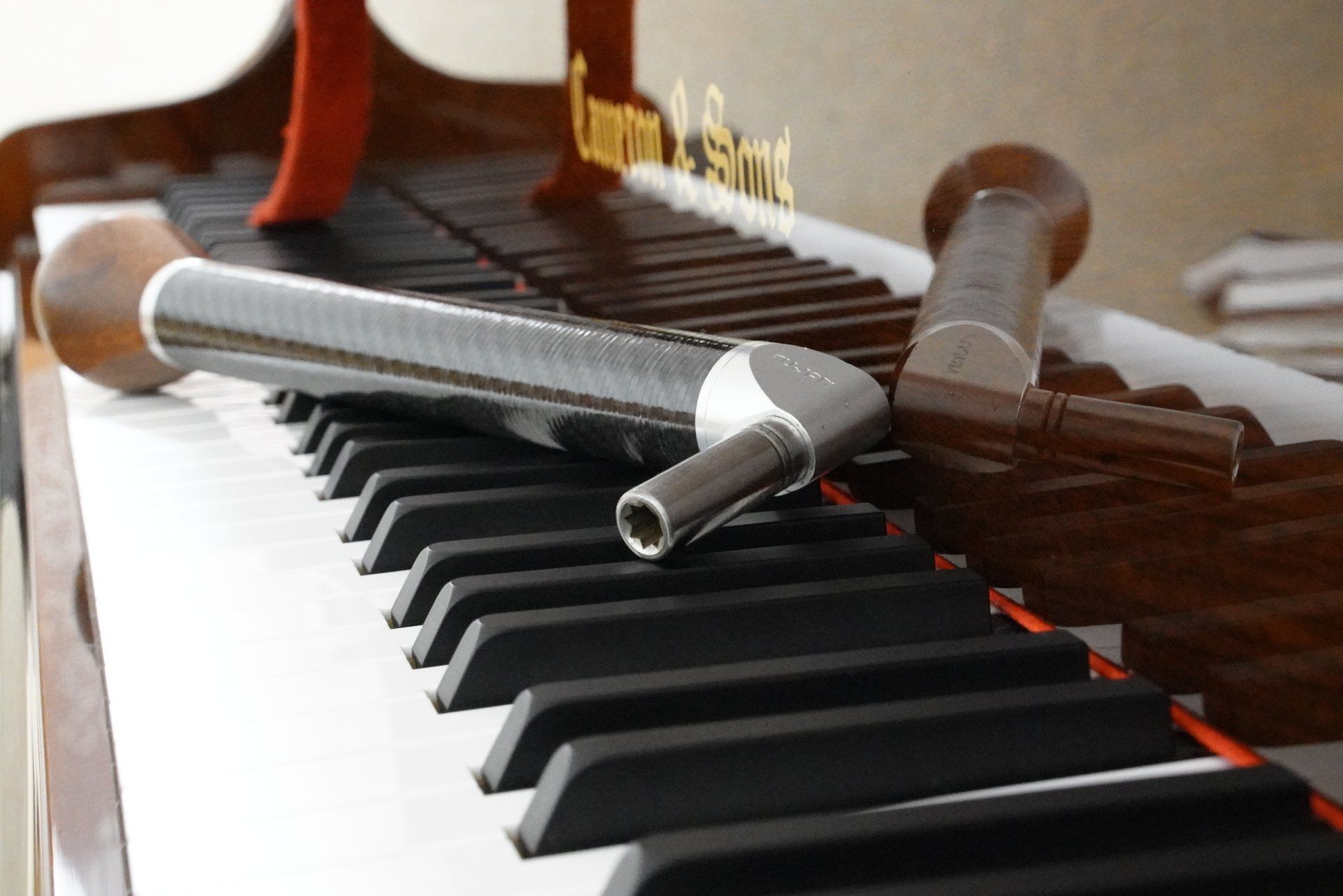 A close up of a piano keyboard with a hammer on it