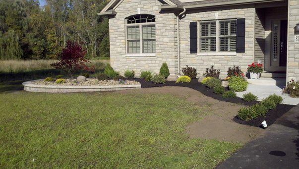a large brick house with a lush green lawn in front of it .