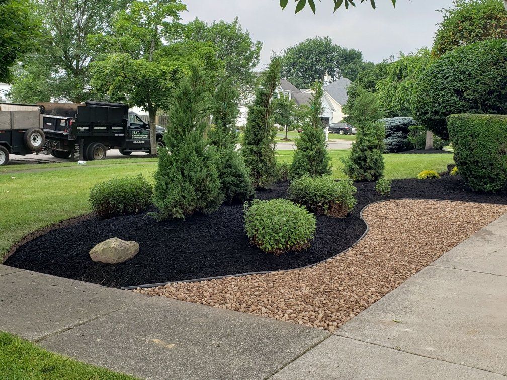 a truck is parked in a driveway next to a garden