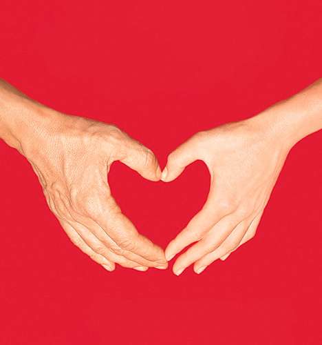 Mains formant un coeur sur un fond rouge