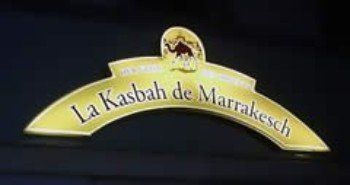 Goldenes Bogenlogo „La Kasbah de Marrakesh“ mit Kamelillustration.