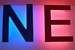Blaues „N“ und rotes „E“ leuchten auf weißem Hintergrund.
