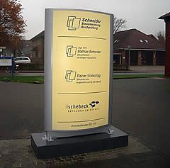 Wegweiser einer Steuerberatungskanzlei mit drei Einträgen und einem Firmenlogo auf einem grauen, gebogenen Display.