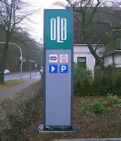 Schild der OLB-Bank mit Kreditkartenlogos und Parkhinweis.