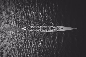 An aerial view of a rowing boat in the water.