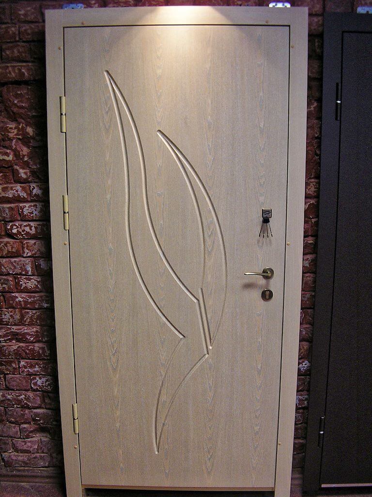 Light-colored interior door with an abstract design, set against a brick wall.