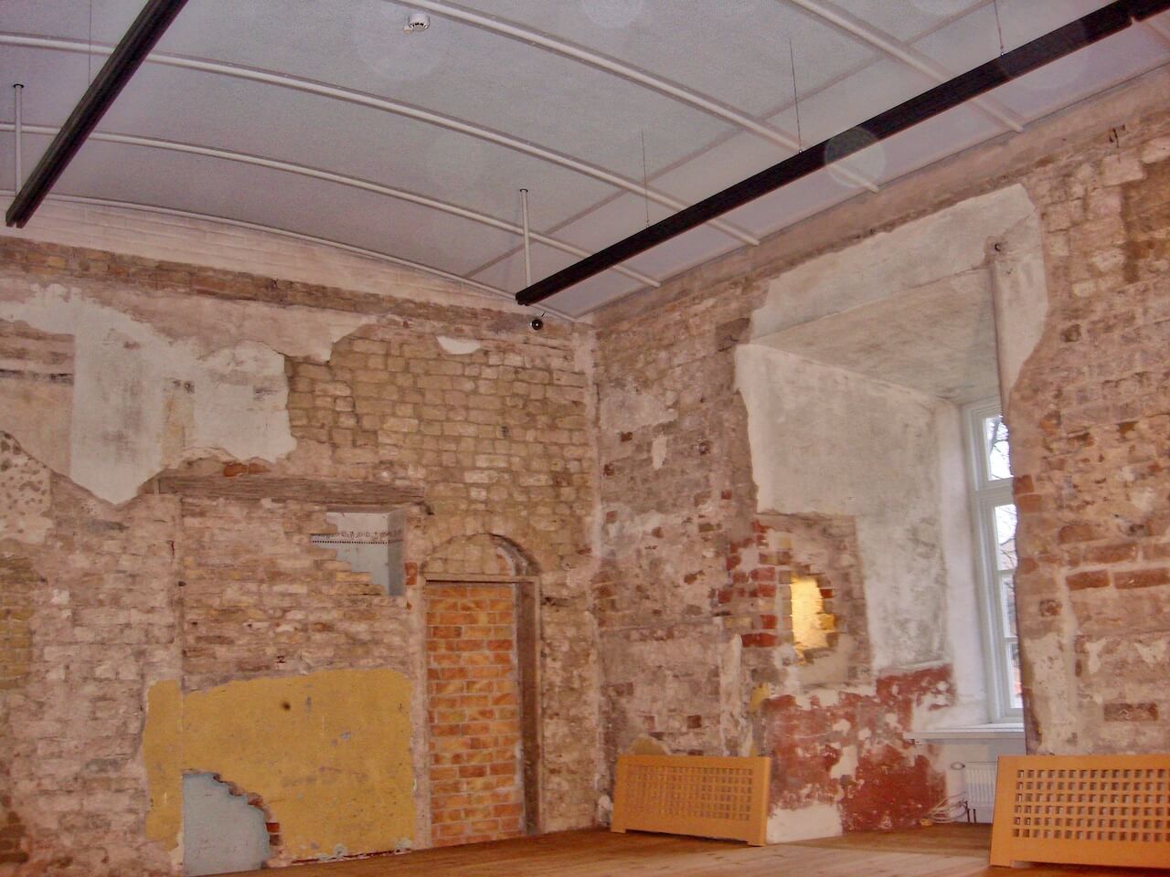 An empty room with a brick wall and a window
