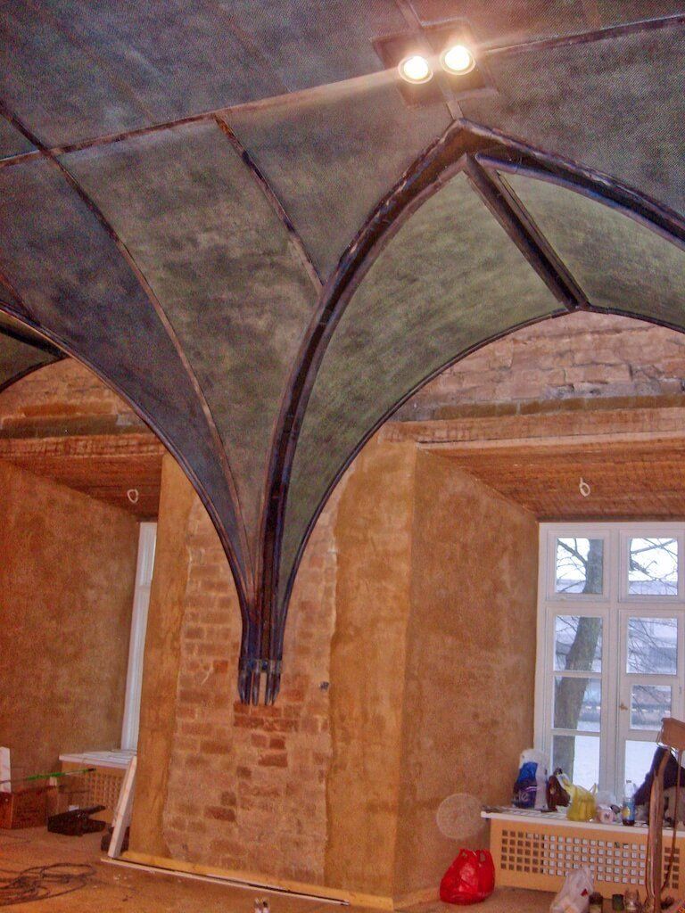 A room with a vaulted ceiling and a brick wall