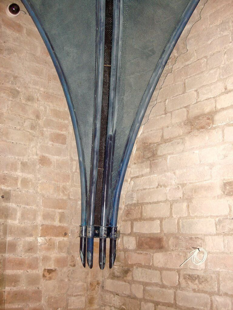 A brick wall with a blue umbrella hanging from it.