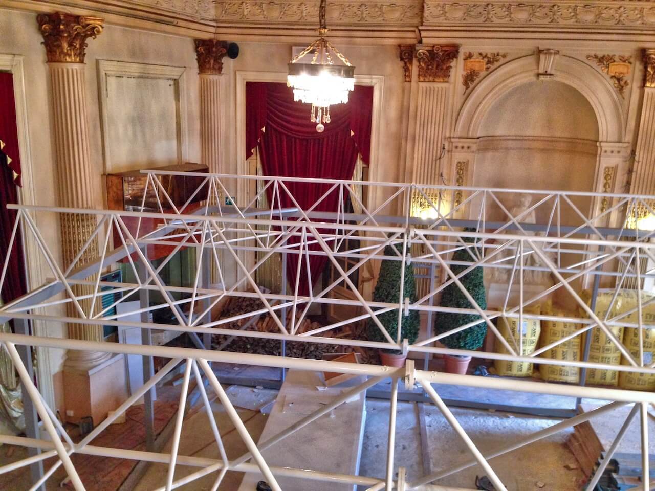 A metal structure is being built in a large room