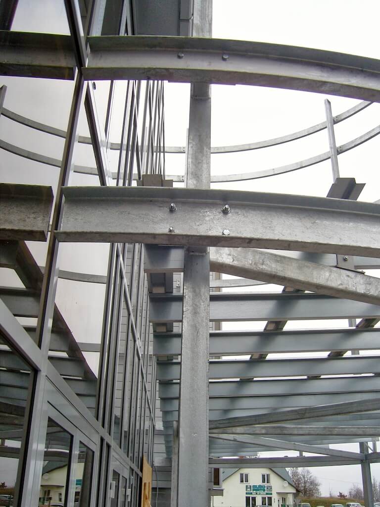 Looking up at a metal structure with a house in the background