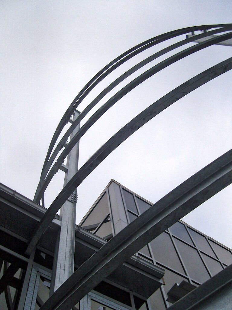 Looking up at a building with a curved metal structure