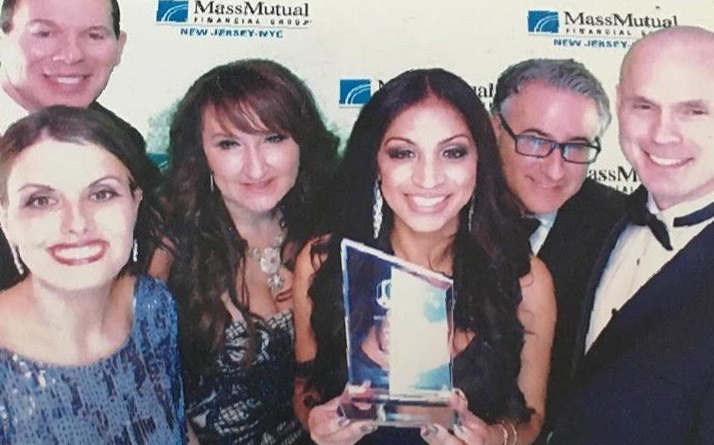 a group of people posing for a photo in front of a wall that says massmutual
