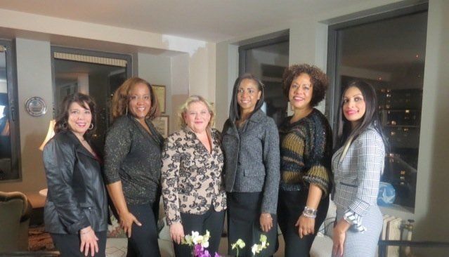 a group of women are posing for a picture in a living room .