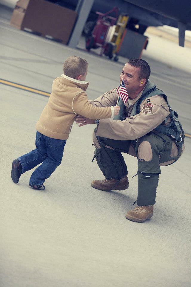 service member hugging child