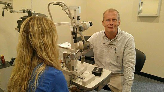 Dr. Tommy Louthan performing a routine eye exam with a femal patient- professional eye care services in Knoxville, TN Dr. Tommy Louthan performing a routine eye exam with a femal patient- professional eye care services in Knoxville, TN