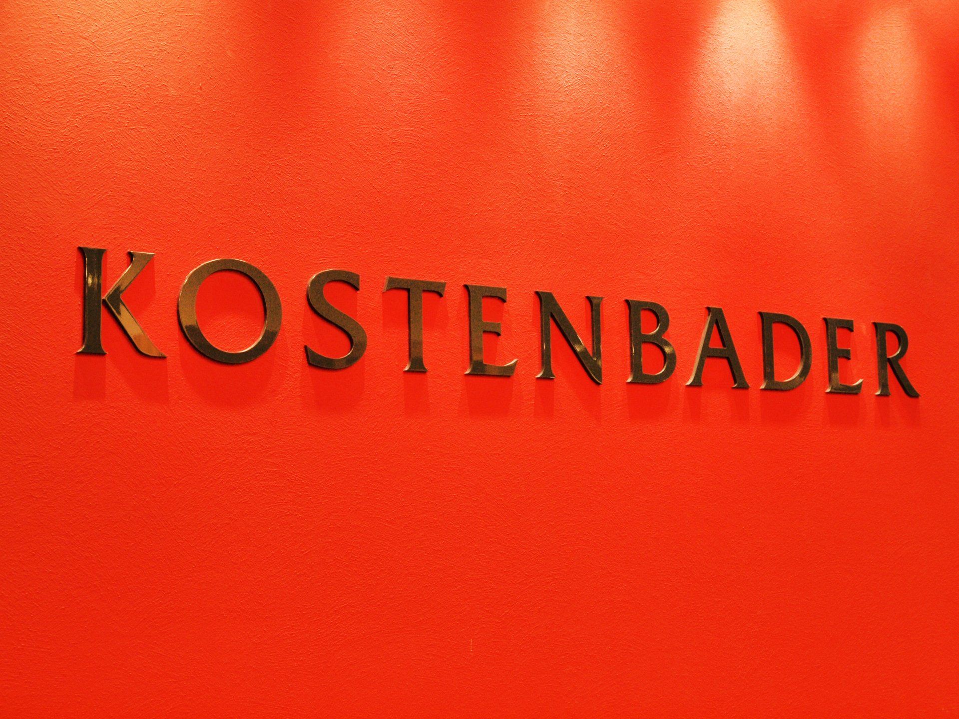 Das Wort Kostenbader steht auf einer roten Wand