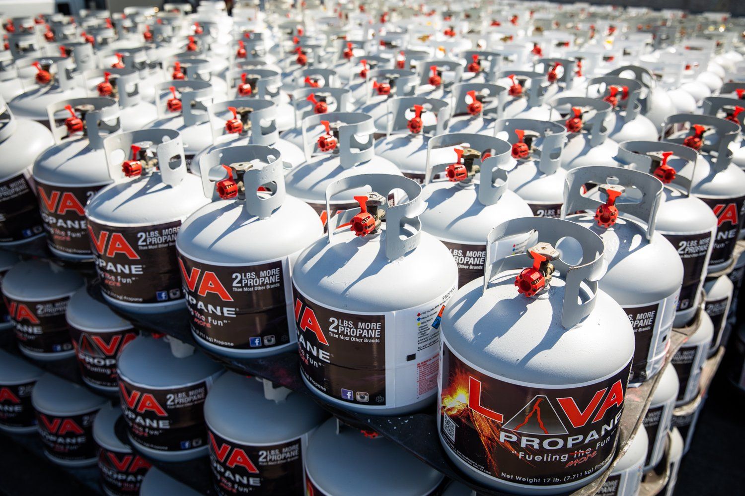 A bunch of propane tanks are stacked on top of each other.