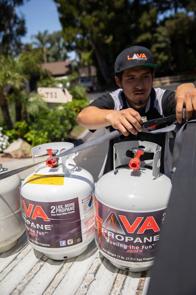 A man is loading propane tanks into a truck.