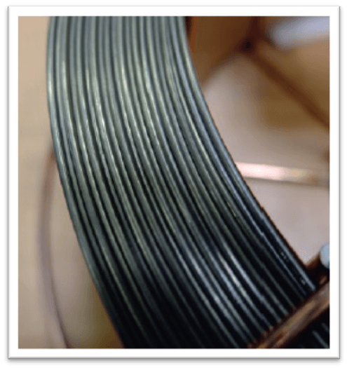 A close up of a spool of black wire