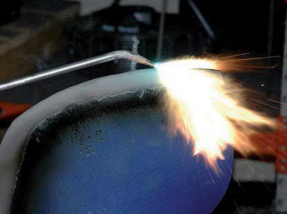 A close up of a torch igniting a piece of metal.