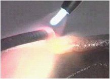 A close up of a torch igniting a piece of metal.