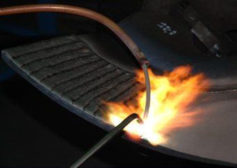 A person is welding a piece of metal with a torch
