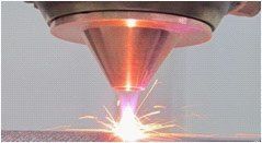 A close up of a laser cutting machine cutting a piece of metal.
